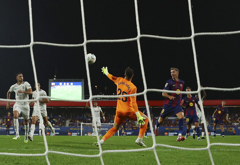 Pemain FC Barcelona Robert Lewandowski mencetak gol keenam mereka melewati pemain Valencia Julen Agirrezabal pada pertandingan Liga Spanyol antara FC Barcelona vs Valencia di Stadion Johan Cruyff, Barcelona, Sapanyol, Senin (15/9/2025) dini hari WIB. Foto: Albert Gea/REUTERS