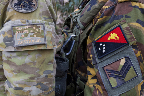 Foto ini menunjukkan lambang seorang prajurit Angkatan Darat Australia (kiri) dan seorang prajurit Pasukan Pertahanan Papua Nugini (PNG) selama latihan di Talisman Sabre di Townsville, Australia (21/7/2025). Foto: LCPL Jessica Gray/Australian Army via AP
