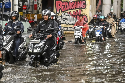 Sejumlah pengendara melintasi genangan air usai hujan deras di depan Pasar Cipulir, Jakarta, Selasa (16/9/2025). Foto: Rivan Awal Lingga/ANTARA FOTO