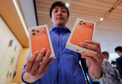 Seorang pria menunjukkan kotak-kotak berisi ponsel pintar seri iPhone 17 yang baru dibeli di dalam toko Apple di kawasan Sanlitun, Beijing, saat dimulainya penjualan di Beijing, China,  Jumat (19/9/2025). Foto: Maxim Shemetov/REUTERS