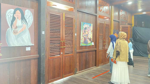 Pengunjung melihat hasil karya lukisan di pameran seni 'Menjaring Tutur'. Foto: Alycia Tracy Nabila/Hi!Pontianak