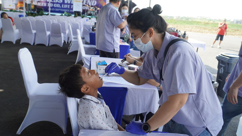 Salah satu dokter gigi dari Fakultas Kedokteran Gigi UK Petra saat memberi pelayanan pemeriksaan gigi gratis. 