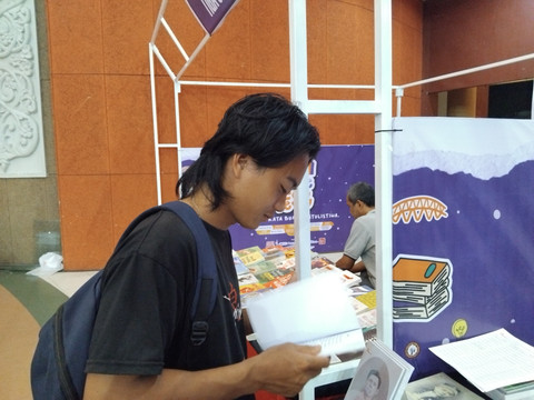 Salah satu pengunjung tampak membaca buku yang dipamerkan. Foto: Dok. Hi!Pontianak