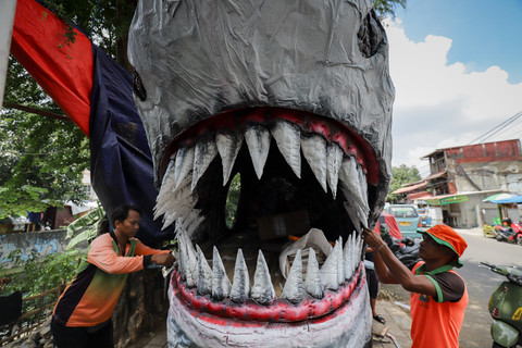 Petugas Unit Penanganan Sampah (UPS) Badan Air Kecamatan Johar Baru menyelesaikan perahu berbentuk ikan hiu di Johar Baru, Jakarta Pusat, Minggu (21/9/2025). Foto: Jamal Ramadhan/kumparan