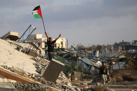 Seorang anak mengibarkan bendera Palestina di atas reuntuhan bangunan di kamp pengungsi Bureij, Jalur Gaza tengah, Senin (22/9/2025). Foto: Eyad BABA / AFP
