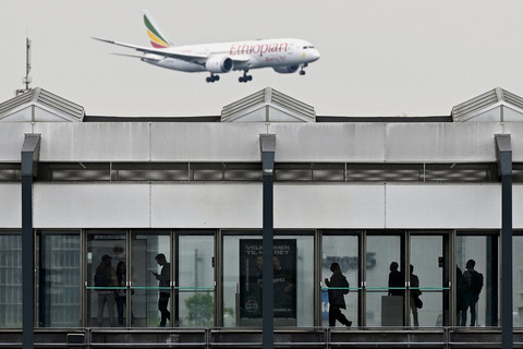 Orang-orang menunggu kereta di stasiun metro saat pesawat penumpang Boeing 787-8 Ethiopian Airlines terbang di langit saat mendarat di Bandara Kopenhagen, Denmark, Rabu (4/9/2025). Foto: Sergei Gapon/AFP