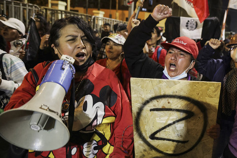 Seorang pengunjuk rasa memegang spanduk bertuliskan huruf "Z", di samping pengunjuk rasa lain yang menggunakan megafon dalam demonstrasi di Lima, Peru, Minggu (28/9/2025). Foto: Sebastian Castaneda/REUTERS