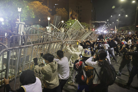 Para pengunjuk rasa menyingkirkan penghalang selama demonstrasi di Lima, Peru, Minggu (28/9/2025). Foto: Sebastian Castaneda/REUTERS