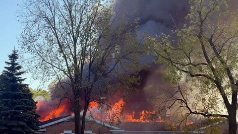 Asap dan api mengepul di lokasi kejadian menyusul insiden seorang pria menabrakkan kendaraannya ke pintu depan sebuah gereja di Michigan, Grand Blanc, Michigan, AS, Senin (29/9/2025). Foto:  Heem Vaniawala/Reuters