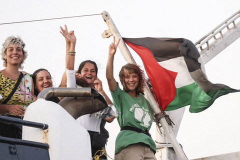 Aktivis lingkungan Swedia Greta Thunberg mengibarkan bendera Palestina dengan sukarelawan saat berlayar dengan flotilla Sumud global melalui blok laut Israel untuk mengirimkan bantuan kemanusiaan ke Gaza di Yunani, Jumat (9/25/2025). Foto: Stefanos Rapanis/Reuters