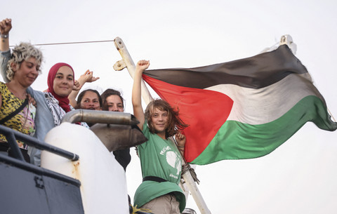 Aktivis lingkungan asal Swedia, Greta Thunberg mengibarkan bendera Palestina bersama para relawan saat berlayar bersama Global Sumud Flotilla menembus blokade laut Israel untuk mengirimkan bantuan kemanusiaan ke Gaza di Yunani, Jumat (25/9/2025). Foto: Stefanos Rapanis/Reuters