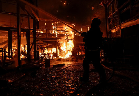 Seorang petugas pemadam kebakaran bekerja di lokasi pasar Barabashovo yang terkena serangan pesawat nirawak Rusia, di tengah serangan Rusia terhadap Ukraina, di Kharkiv, Ukraina, 1 Oktober 2025. Foto: REUTERS/Sofiia Gatilova