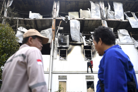Polisi berada di samping tower 14 pascakebakaran hunian pekerja konstruksi (HPK) 1 di Ibu Kota Nusantara (IKN), Penajam Paser Utara, Kalimantan Timur, Kamis (2/10/2025). Foto: M Risyal Hidayat/ANTARA FOTO