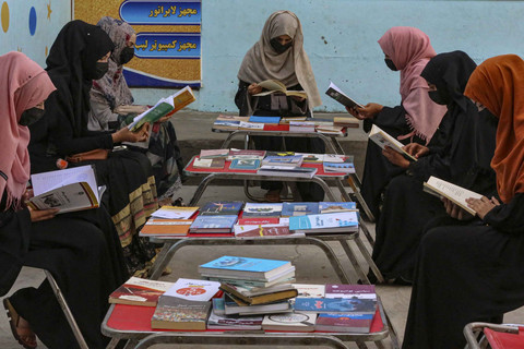 Perempuan Afghanistan membaca buku di perpustakaan. Foto: SHAFIULLAH KAKAR/AFP