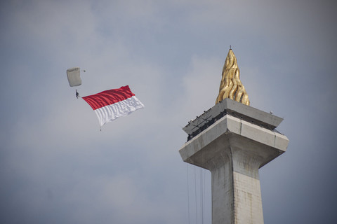 Aksi penerjun kibarkan bendera Merah Putih dalam peringatan Hari Ulang Tahun (HUT) ke-80 Tentara Nasional Indonesia (TNI) di Lapangan Silang Monumen Nasional (Monas), Jakarta Pusat, Minggu (5/10/2025). Foto: Jamal Ramadhan/kumparan