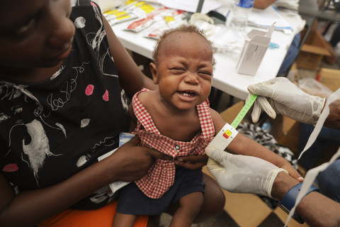 Seorang anak yang kekurangan gizi diperiksa oleh dokter dari apotek keliling di tempat penampungan bagi keluarga yang mengungsi akibat kekerasan geng di Port-au-Prince, Haiti, Selasa (7/10/2025). Foto: Patrice Noel/AP Photo
