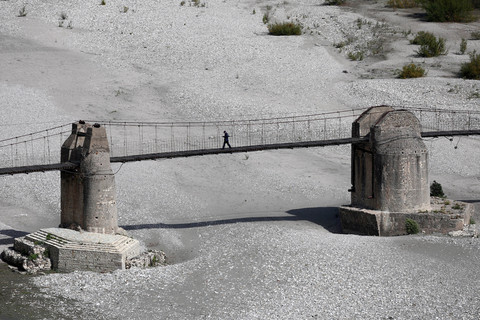 Seorang pria berjalan di jembatan di tepi lembah Vjosa, yang baru-baru ini ditetapkan sebagai situs UNESCO, di Tepelene, Albania, 5 Oktober 2025. Foto: REUTERS/Florion Goga