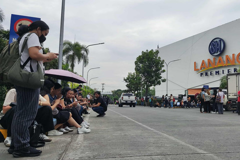 Para karyawan sebuah pusat perbelanjaan berkumpul di luar gedung di Kota Davao, di pulau selatan Mindanao, pada 10 Oktober 2025, setelah gempa berkekuatan 7,4 skala Richter melanda Filipina selatan. Foto: Bobbie ALOTA / AFP