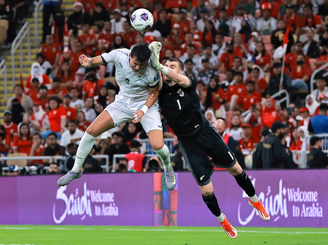 Penjaga gawang Timnas Indonesia Maarten Paes berebut bola dengan pemain Timnas Irak Munaf Younus pada pertandingan Grup B Ronde 4 Kualifikasi Piala Dunia 2026 di King Abdullah Sports City Stadium, Jeddah, Arab Saudi, Sabtu (11/10/2025). Foto: Stringer/REUTERS