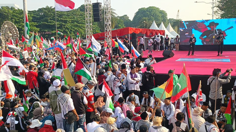 Massa aksi bela Palestina di depan panggung utama, mereka membawa bendera negara-negara pendukung Two State Solution, Minggu (12/10). Foto: Zamachsyari/kumparan