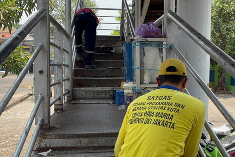Petugas memperbaiki jembatan penyeberangan orang (JPO) Halte Transjakarta Kramat Jati, Jakarta, Minggu (12/10/2025). Foto: Abid Raihan/kumparan
