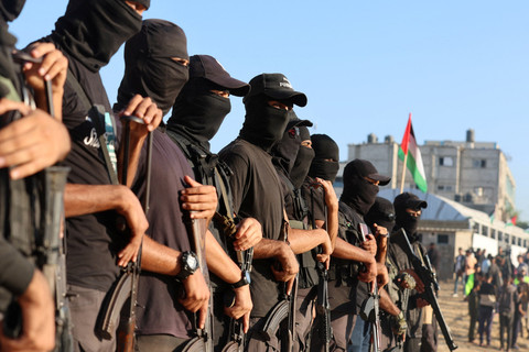 Militan Palestina berjaga jelang pembebasan sandera Israel yang ditawan Hamas di Khan Younis, Jalur Gaza, Senin (13/10/2025). Foto: Ramadan Abed/REUTERS