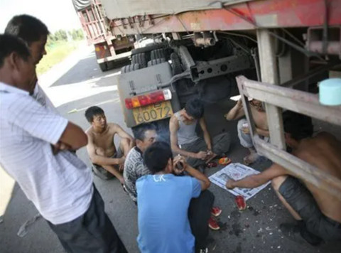 Supir truk yang bermain kartu saat terjebak macet di Jalan Tol Beijing-Tibet di China. Foto: Dok. AP