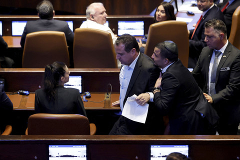 Anggota Knesset Ayman Odeh dikeluarkan dari aula setelah mengangkat spanduk saat Presiden AS Donald Trump berpidato di hadapan Knesset, parlemen Israel di Yerusalem, Senin (13/10/2025). Foto: Chip Somodevilla/Pool via REUTERS