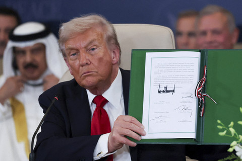 Presiden AS Donald Trump berpose dengan perjanjian yang telah ditandatangani pada pertemuan puncak para pemimpin dunia untuk mengakhiri perang Gaza di Sharm el-Sheikh, Mesir, Senin (13/10/2025). Foto: Suzanne Plunkett/ REUTERS