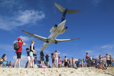 Wisatawan yang melihat pesawat yang hendak mendarat di Princess Juliana International Airport, Saint Maarten, Kepulauan Karibia. Foto: Captain Wang/Shutterstock