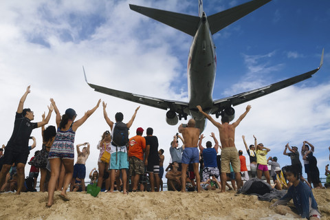 Wisatawan yang melihat pesawat yang hendak mendarat di Princess Juliana International Airport, Saint Maarten, Kepulauan Karibia. Foto: Captain Wang/Shutterstock