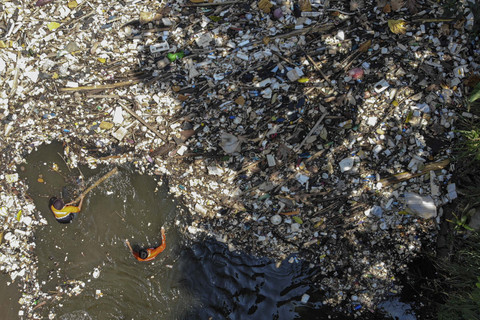 Foto udara petugas Dinas Lingkungan Hidup (DLH) Kabupaten Bogor membersihkan tumpukan sampah di aliran irigasi Sungai Cikaret, Cibinong, Kabupaten Bogor, Jawa Barat, Selasa (14/10/2025). Foto: Yulius Satria Wijaya/ANTARA FOTO