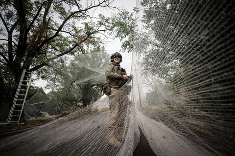 Seorang prajurit dari Brigade Mekanik ke-24 dari Angkatan Bersenjata Ukraina memasang jaring anti-pesawat tak berawak di atas jalan di kota garis depan Kostiantynivka di wilayah Donetsk, Ukraina (19/9/2025). Foto: UKRAINIAN ARMED FORCES via REUTERS