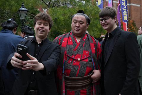 Rikishi (pegulat sumo) Tamawashi (tengah) berpose untuk berfoto bersama para penggemar di luar Royal Albert Hall di pusat kota London, Rabu (15/10/2025). Foto: CARLOS JASSO/AFP