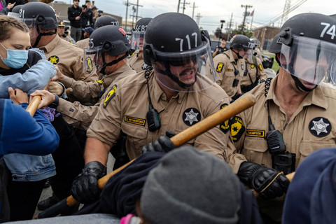 Anggota kepolisian Negara Bagian Illinois bentrok dengan pengunjuk rasa di luar fasilitas ICE Broadview di Chicago, Illino, Jumat (17/10/2025). Foto: JIM VONDRUSKA/REUTERS