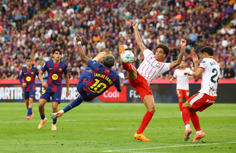 Lamine Yamal dari FC Barcelona beraksi bersama Axel Witsel dari Girona pada pertandingan Liga Spanyol antara FC Barcelona vs Girona di Estadi Olimpic Lluis Companys, Barcelona, Spanyol, Sabtu (18/10/2025). Foto: Albert Gea/REUTERS