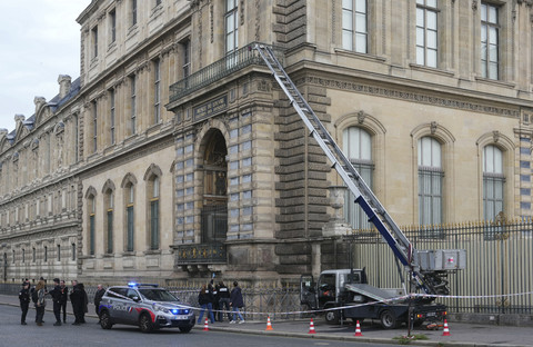 Petugas kepolisian Prancis berdiri di samping lift barang yang digunakan oleh para perampok untuk masuk ke Museum Louvre di Quai Francois Mitterrand, Paris, Minggu (19/10/2025). Foto: Dimitar Dilkoff/AFP