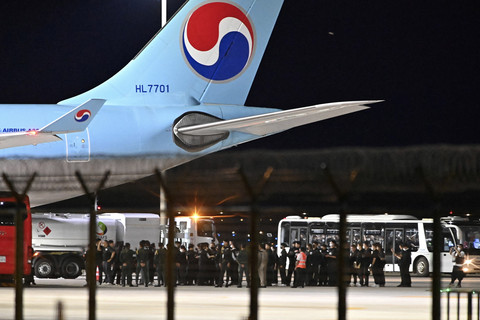Pejabat kepolisian Kamboja dan Korea Selatan berdiri di dekat pesawat sewaan dari Korea Selatan untuk menjemput warga Korea Selatan yang ditahan di Bandara Internasional Incheon, Seoul, Korea Selatan, Sabtu (18/10/2025).  Foto: Yonhap/AFP