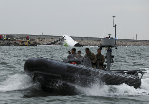 Petugas darurat melakukan pencarian korban dari pesawat kargo yang tergelincir dari landasan pacu saat mendarat di di Bandara Internasional Hong Kong, Hong Kong, Senin (20/10/2025). Foto: Tyrone Siu/Reuters