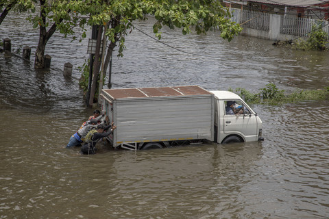 Sejumlah warga bergotong royong mendorong sebuah truk yang mogok seusai menembus genangan banjir jalur utama pantura Semarang-Surabaya, Jalan Kaligawe Raya, Semarang, Jawa Tengah, Kamis (23/10/2025). Foto: Aji Styawan/ANTARA FOTO