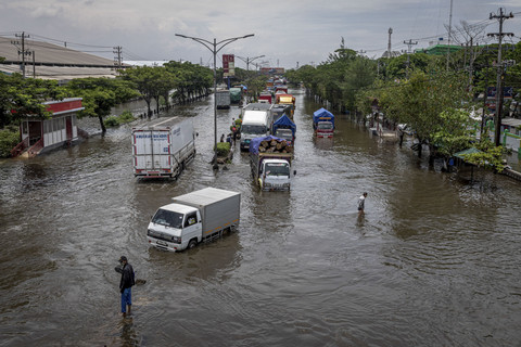 Sejumlah kendaraan bermotor melaju perlahan melewati banjir di jalur utama pantura Semarang-Surabaya, Jalan Kaligawe Raya, Semarang, Jawa Tengah, Kamis (23/10/2025). Foto: Aji Styawan/ANTARA FOTO