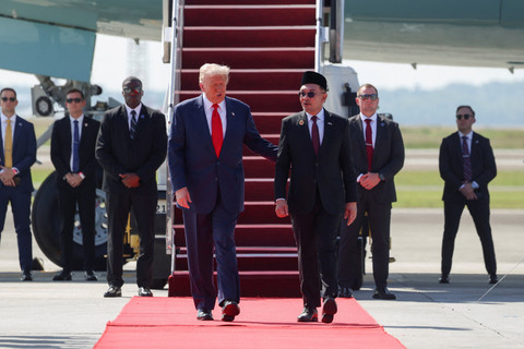 Perdana Menteri Malaysia Anwar Ibrahim menyambut Presiden Amerika Serikat Donald Trump saat tiba di Bandara Internasional Kuala Lumpur di Sepang, Malaysia, Minggu (26/10/2025). Foto: Evelyn Hockstein/REUTERS
