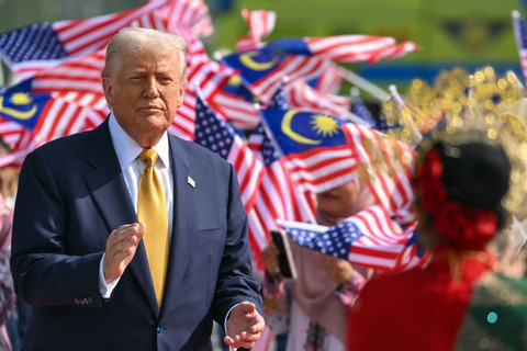 Presiden AS Donald Trump berfoto di samping bendera nasional Malaysia sebelum berangkat dengan Air Force One dari Bandara Internasional Kuala Lumpur di Sepang, Malaysia, dalam perjalanan menuju Jepang, Senin (27/10/2025). Foto: Andrew Caballero-Reynolds/AFP