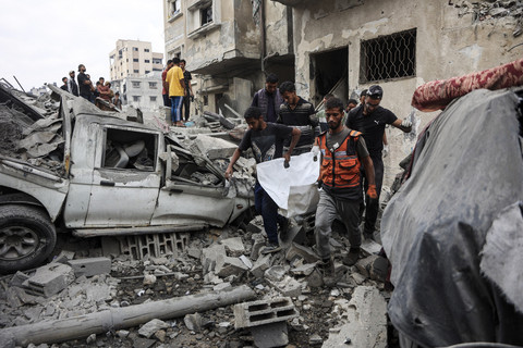 Sejumlah warga Palestina mengevakuasi jenazah dari puing-puing rumah yang hancur akibat serangan Israel di Kota Gaza, Rabu (29/10/2025). Foto: OMAR AL-QATTAA/AFP