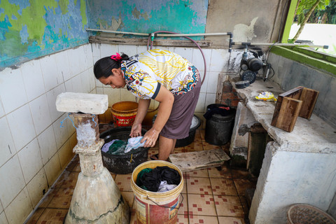 Seorang warga mencuci pakaian di Kampung Apung, Kapuk Teko, Kalideres, Jakarta Barat. Foto: Iqbal Firdaus/kumparan