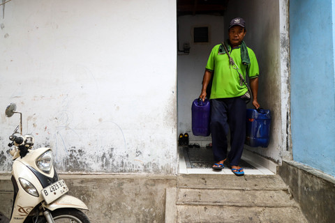 Seorang pedagang air bersih keliling di Kampung Apung, Kapuk Teko, Kalideres, Jakarta Barat. Foto: Iqbal Firdaus/kumparan