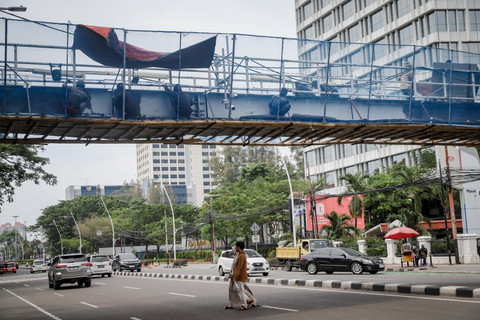 Pekerja mengerjakan perbaikan Jembatan Penyeberangan Orang (JPO) Gambir di Jalan Medan Merdeka Timur, Jakarta, Minggu (2/11/2025). Foto: Jamal Ramadhan/kumparan