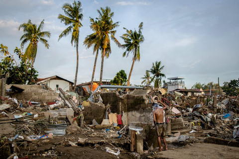Seorang pria mandi di tengah sisa-sisa pemukiman warga yang rumahnya tersapu banjir akibat Topan Kalmaegi di Talisay, Cebu, Filipina, 6 November 2025. Foto: REUTERS/Eloisa Lopez