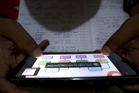 Pengemudi ojek online, Anto saat mengikuti kelas pelatihan dari Kemnaker di rumahnya. Foto: Febria Adha Larasati/kumparan