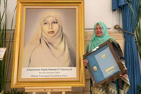 Pimpinan Perguruan Diniyyah Puteri Padang Panjang Fauziah Fauzan El Muhammady berfoto di samping foto Rahmah El Yunusiyyah di Istana Negara Jakarta, Senin (10/11/2025). Foto: HO-Humas Diniyyah Puteri Padang Panjang/Antara